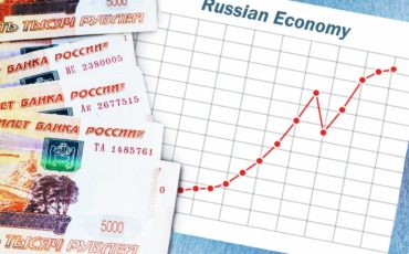 Банкноты российских рублей и график роста экономики