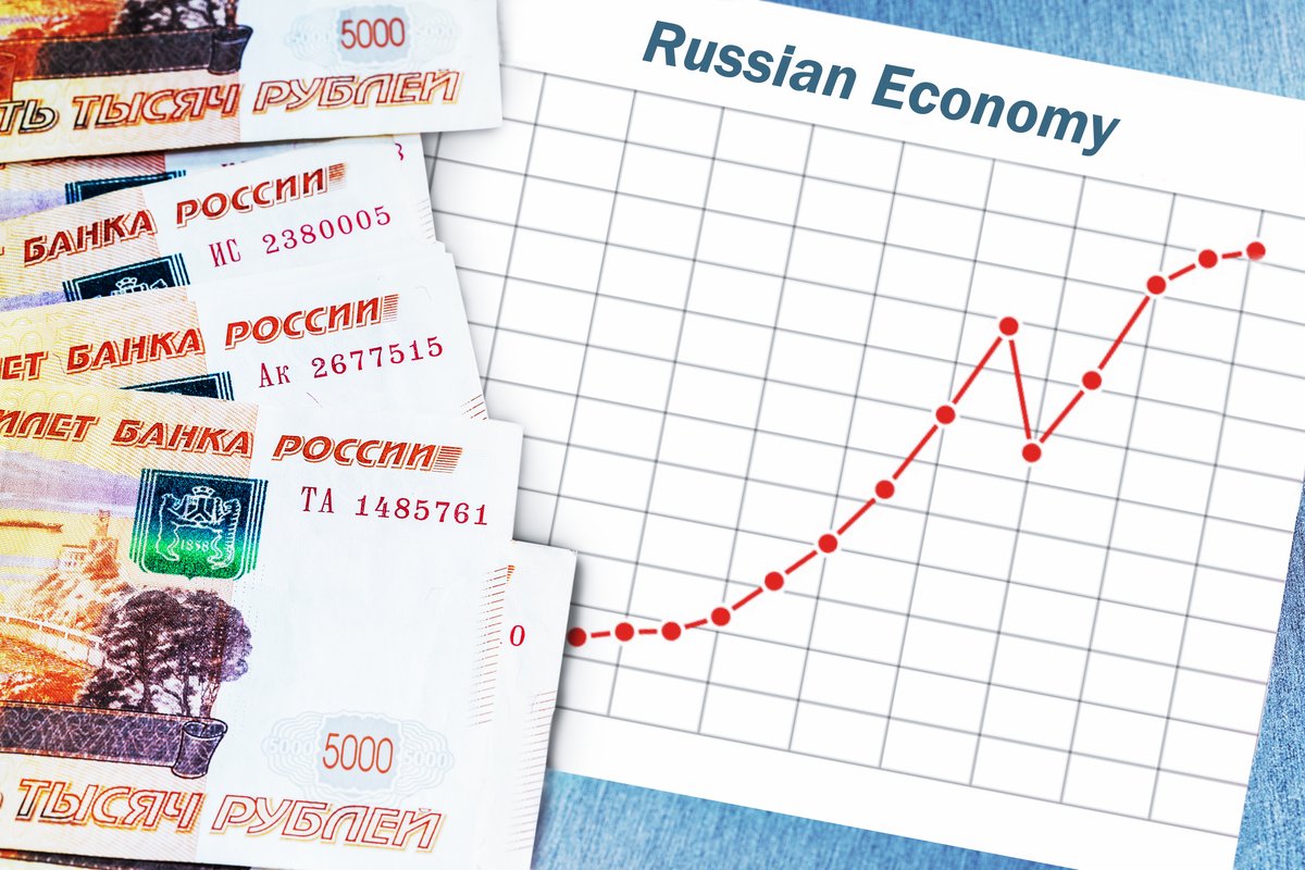 Банкноты российских рублей и график роста экономики